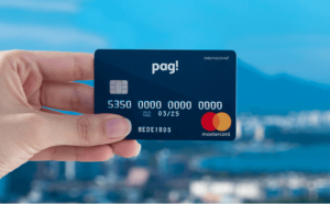 Uma mão segurando o cartão MeuPag! Com um belo plano de fundo