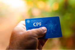 mão segurando um cartão CPF para representar como consultar CPF negativado