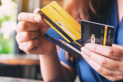 Mão segurando três cartões de crédito diferentes