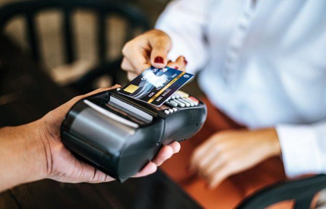 mulher fazendo pagamento para representar como desbloquear cartão de crédito