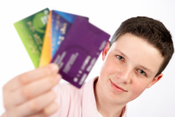 adolescente segurando cartões de crédito