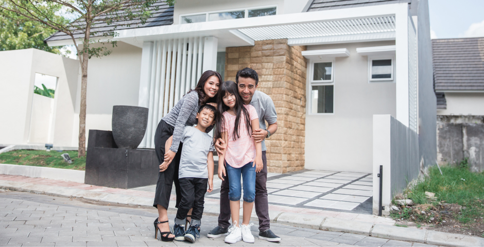 família em frente a uma casa comprada com carta de crédito de consórcio
