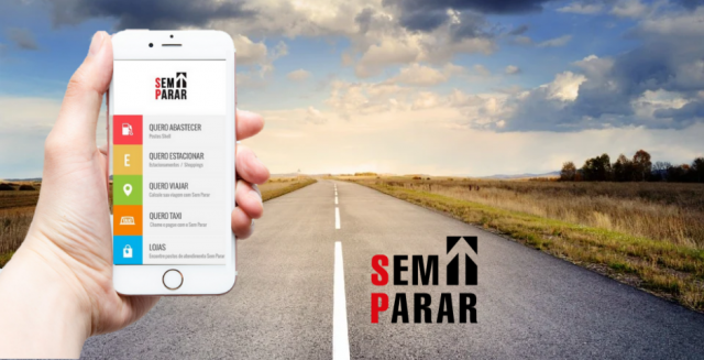 mão segurando um celular com o app sem parar e uma estrada ao fundo