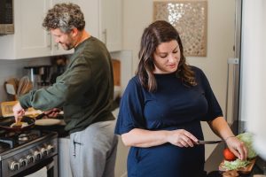 Casal cozinhando junto em casa para reduzir a despesa mensal