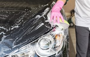 mão lavando carro com balde para economizar na conta de agua
