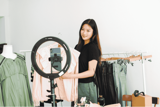 mulher apresentando roupas na internet simbolizando os melhores produtos para revender