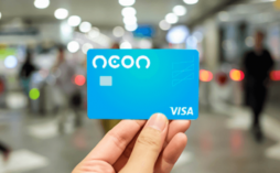 uma mão segurando o cartão neon visa internacional