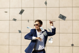 mais ricos do brasil - Imagem de um homem de terno jogando dinheiro pra cima