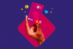 Uma mão segurando o cartão pré-pago Ame Digital em um fundo roxo