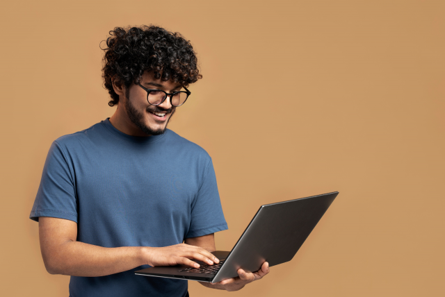 homem sorrindo e segurando um notebook para ganhar dinheiro com upload