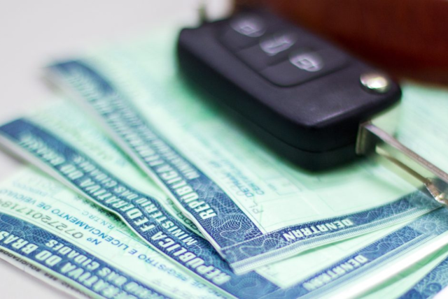 chave de carro em cima de boletos de IPVA