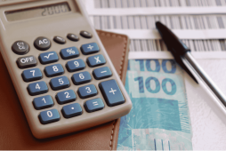 calculadora, dinheiro e boletos para representar o Cedente e Sacado no Boleto Bancário
