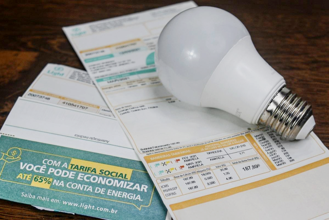 faturas de conta de luz e uma lâmpada em cima para representar o tema Empréstimo na conta de luz pelo WhatsApp