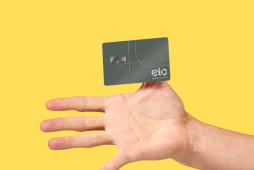Mão segurando um cartão de crédito da bandeira Elo Grafite