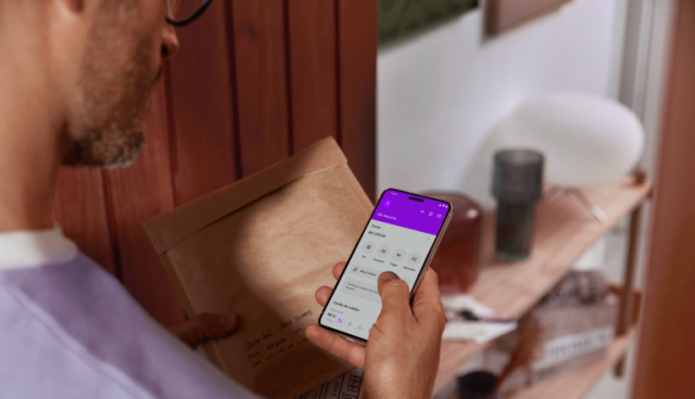 homem olhando para celular com a conta nubank aberta- Conta PJ Nubank: tudo o que você precisa saber