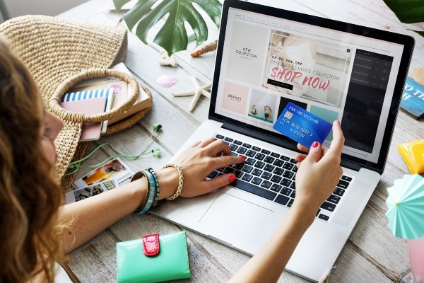 pessoa fazendo compras no computador para representar como Comprar em Sites Estrangeiros é Seguro? Saiba Tudo Aqui