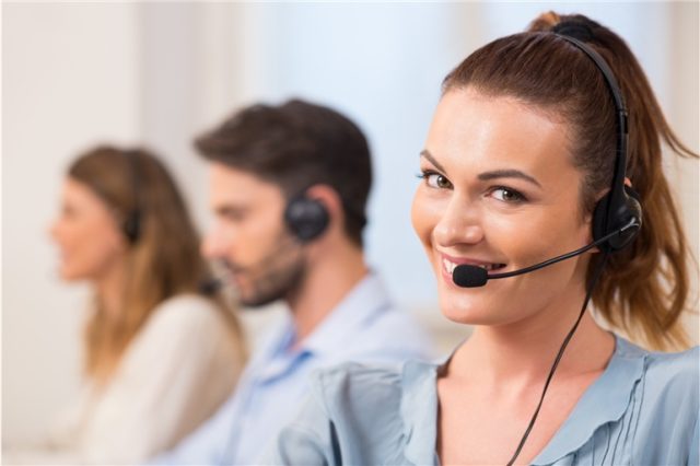 Mulher usando telefone auricular e sorrindo para representar a central de atendimento Hipercard