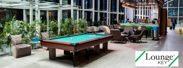 espaço no aeroporto com bebidas, uma mesa de sinuca e sofá, que se chama Sala VIP LoungeKey