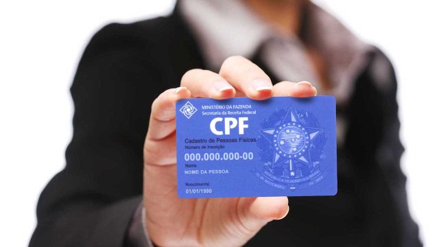 mulher segurando um cartão de CPF- situação cadastral do seu CPF