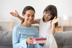 uma filha entregando presentes financeiros para o dia das mães a sua mãe