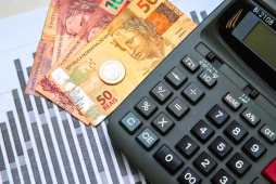 notas de dinheiro real e uma calculadora para cálculo de impostos