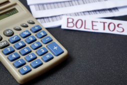 mesa com boletos e calculadora para pagar boletos com cartão