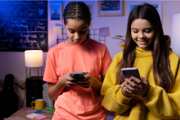 duas jovens no celular usando bancos digitais para crianças e adolescentes