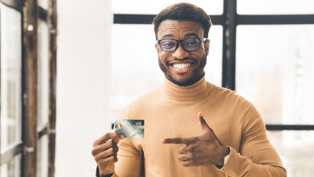 homem feliz segurando um cartão de crédito