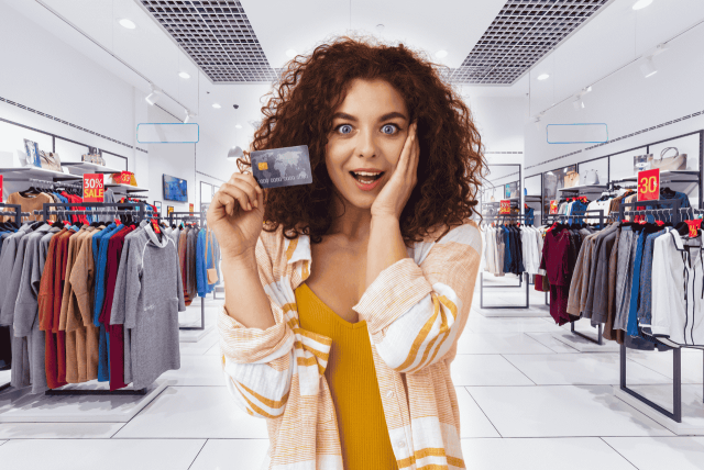 uma mulher com expressão de surpresa segurando um cartão de loja de roupas