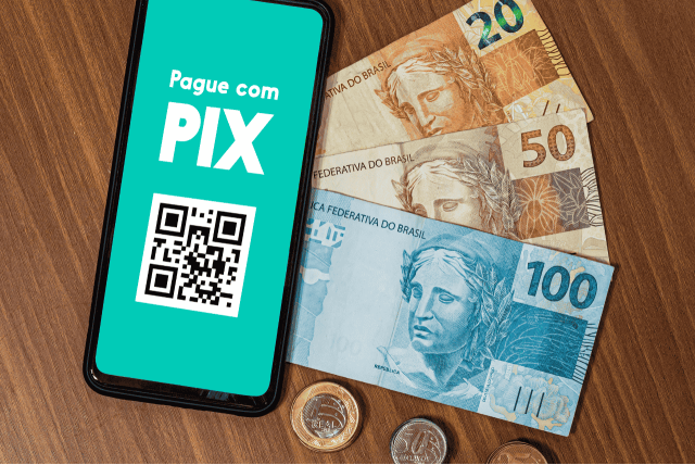 celular e dinheiro sobre uma mesa para exemplificar Como saber onde tenho chave Pix cadastrada