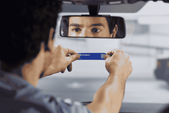 homem instalando a Tag Porto Bank no vidro do carro
