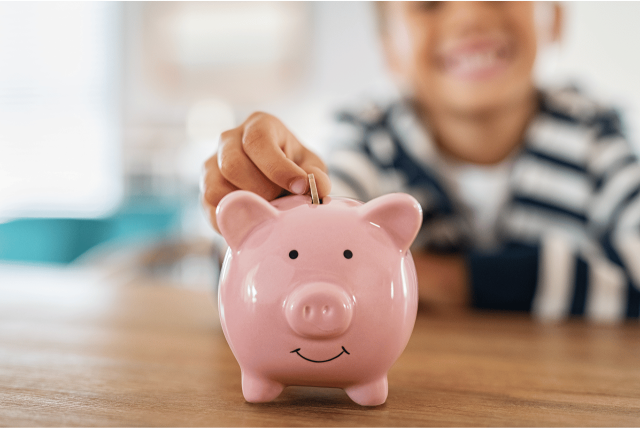 criança depositando moeda em um cofrinto para representar a conta infantil mercado pago