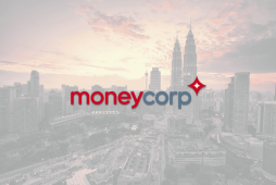 logotipo do Moneycorp Banco de Câmbio com uma cidade ao fundo