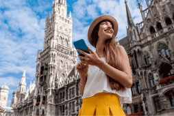 uma mulher com o celular na mão escolhendo as melhores contas internacionais