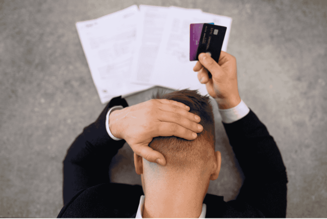 homem segurando cartão com expressão de preocupação para representar a Dívida de cartão de crédito pode bloquear CPF
