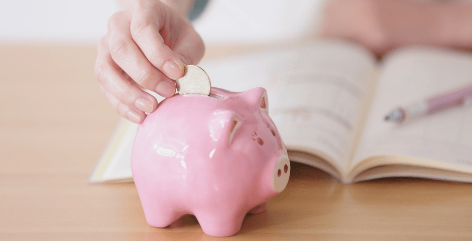 uma pessoa depositando uma moeda em um cofrinho representando a poupança