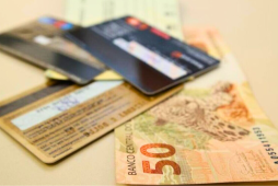 cartão de crédito e nota de 50 reais representado a pergunta se vale a pena pagar anuidade do cartão de crédito