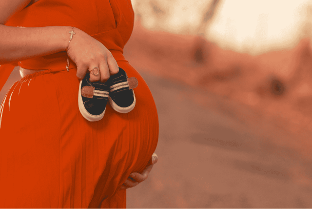 mulher grávida segurando sapatos de bebê para representar a sexagem fetal valor