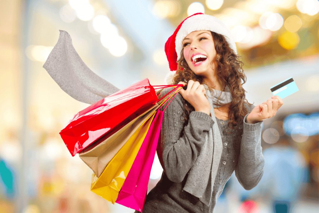 mulher sorrindo segurando sacolas de compras após Aproveitar as promoções de fim de ano