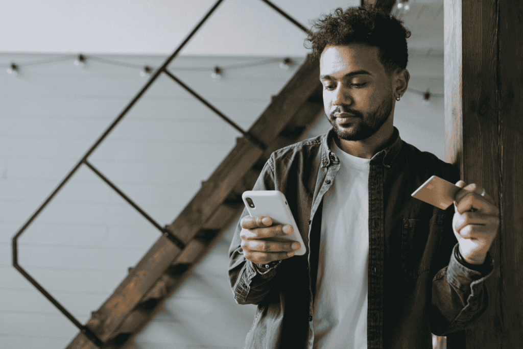 homem usando celular para descobrir Qual cartão de crédito libera limite na hora