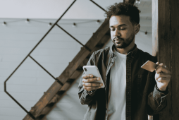 homem usando celular para descobrir Qual cartão de crédito libera limite na hora