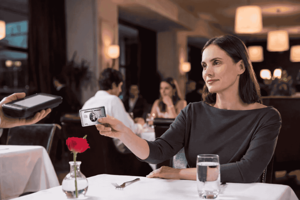 mulher pagando conta em restaurante com cartão amex para representar 5 coisas que você precisa saber sobre os cartões da American Express