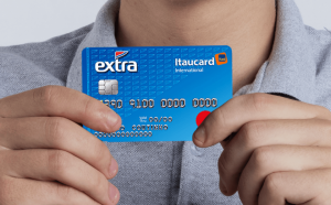 um homem segurando o cartão de crédito Extra Itaucard Internacional Mastercard